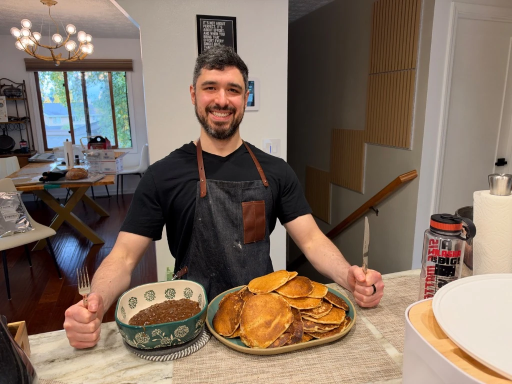 A stack of sourdough pancakes and fresh baking on a kitchen counter