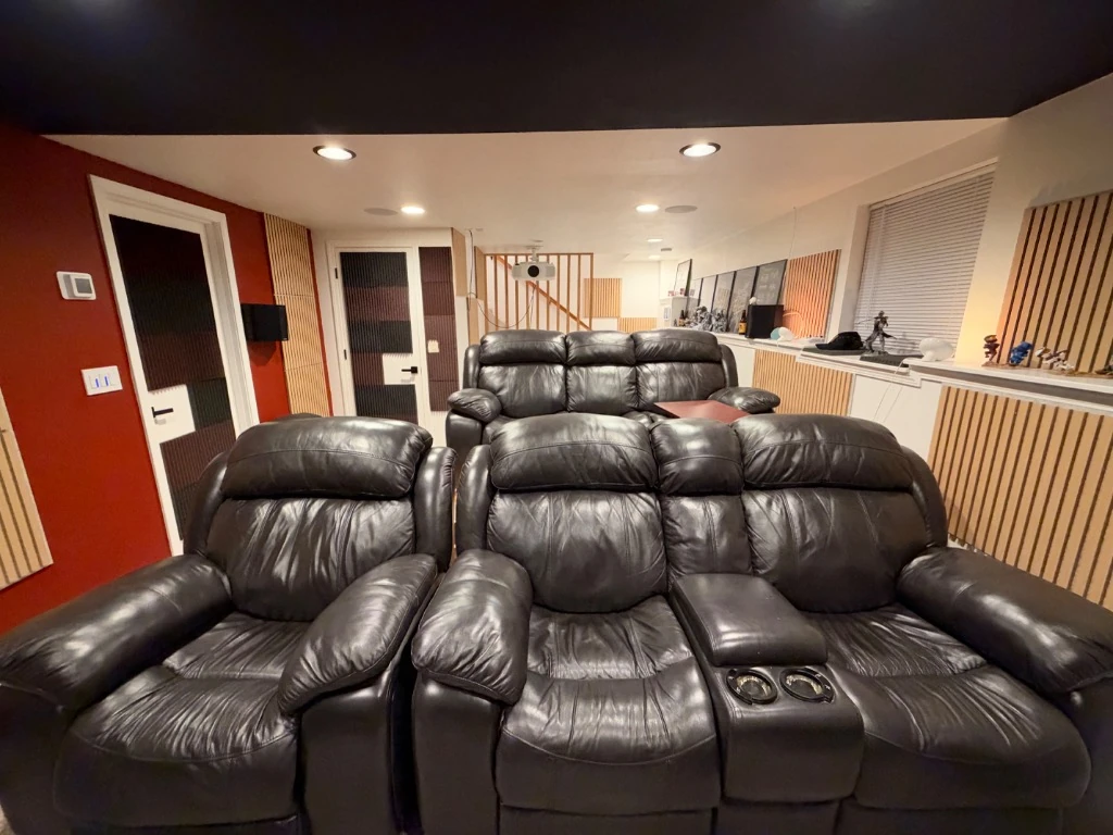 Custom home theater rear room view showing two rows of leather seating, projector, and in-ceiling Atmos speakers